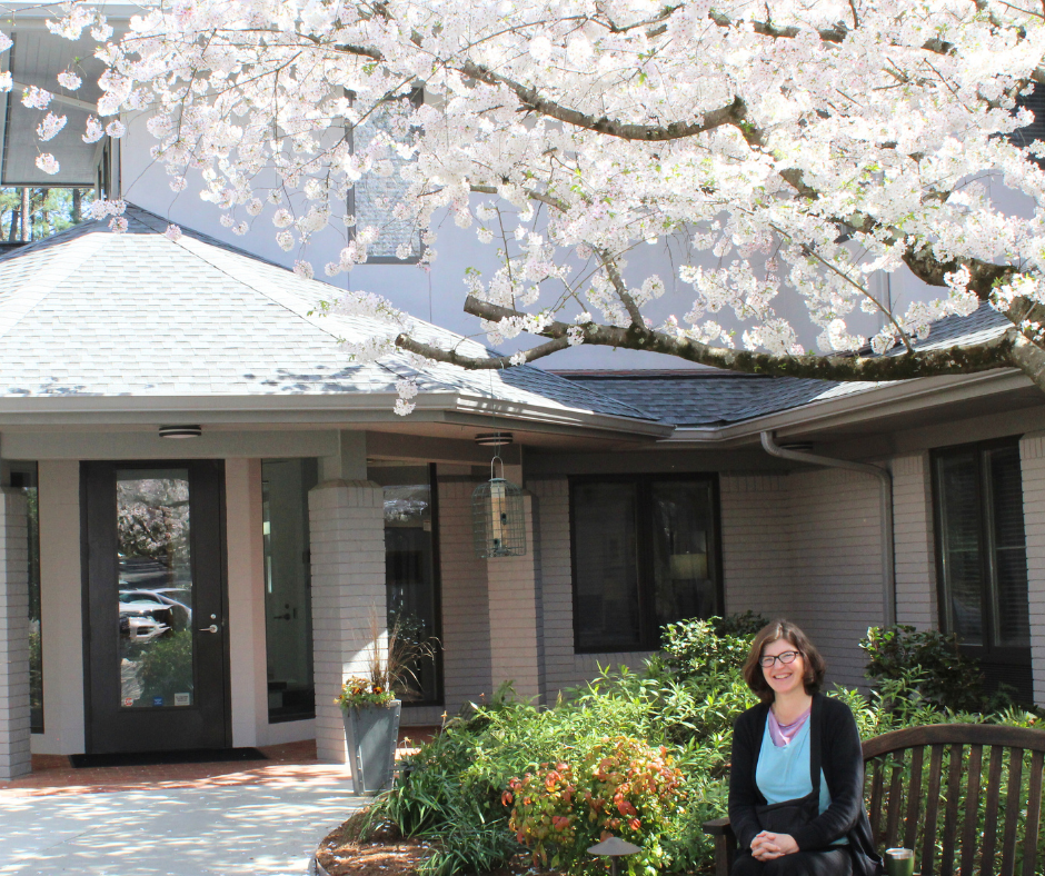 Cancer patient in front of Caring House and Cherry Blossom Trees